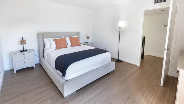 a bedroom with a bed and wooden floor