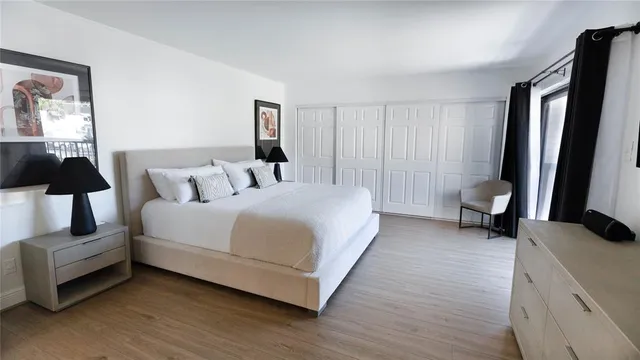 a spacious bedroom with a bed and a lamp on table