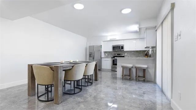 a view of a dining room with furniture and a kitchen