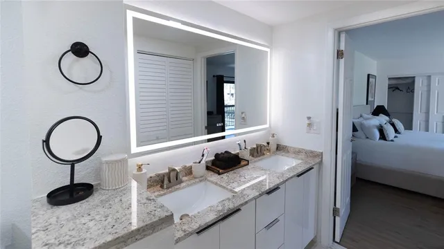 a bathroom with a granite countertop sink a toilet a and mirror