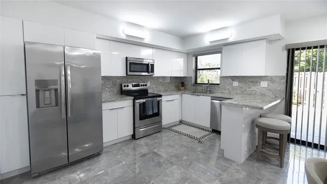 a kitchen with a refrigerator a sink a stove a microwave and cabinets