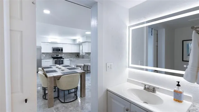 a kitchen that has a sink cabinets and chair in it