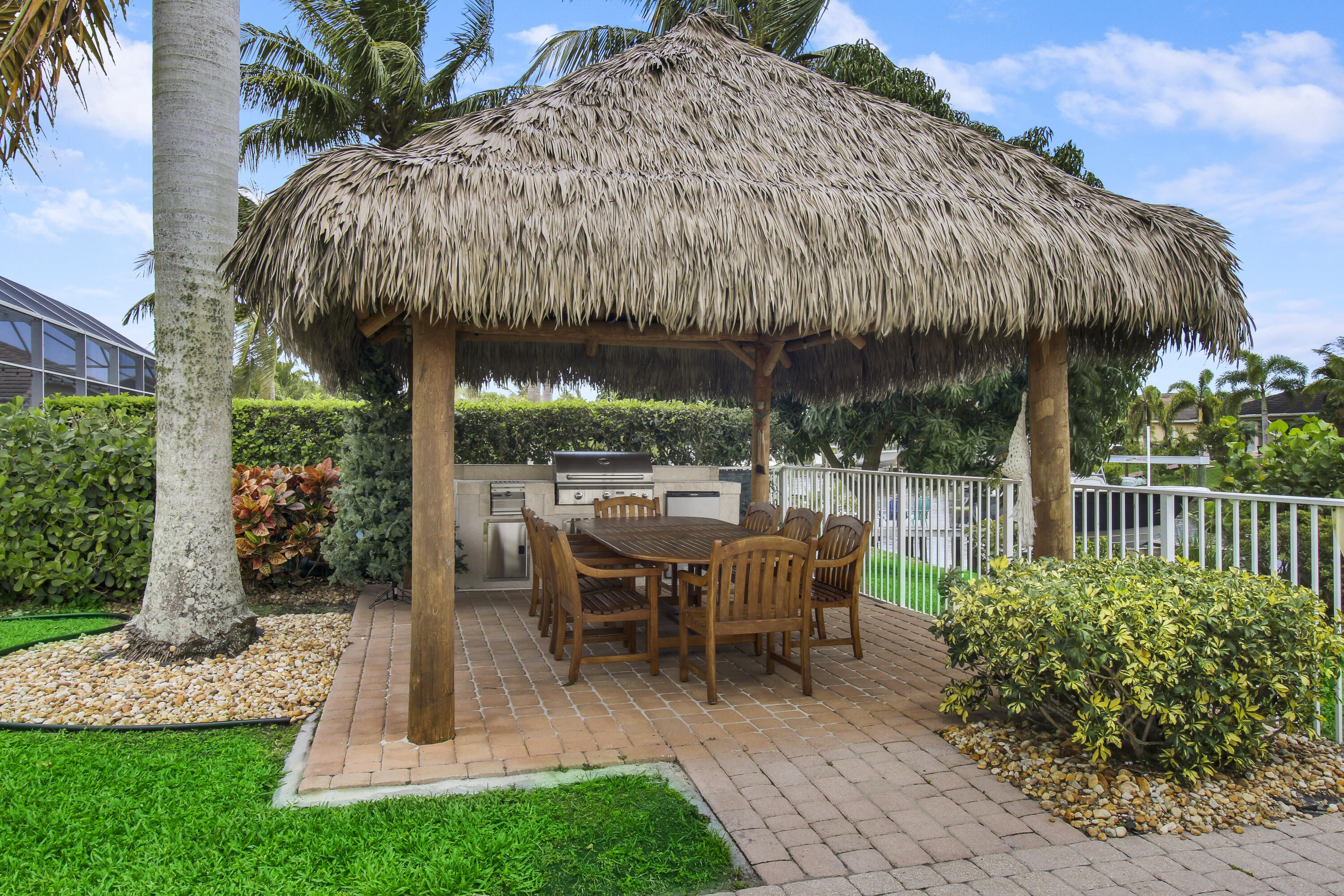 660 Southwest Yacht Basin Way Stuart, FL 34997 - Photo 32 of 42 a view of a patio with table and chairs under an umbrella with a yard