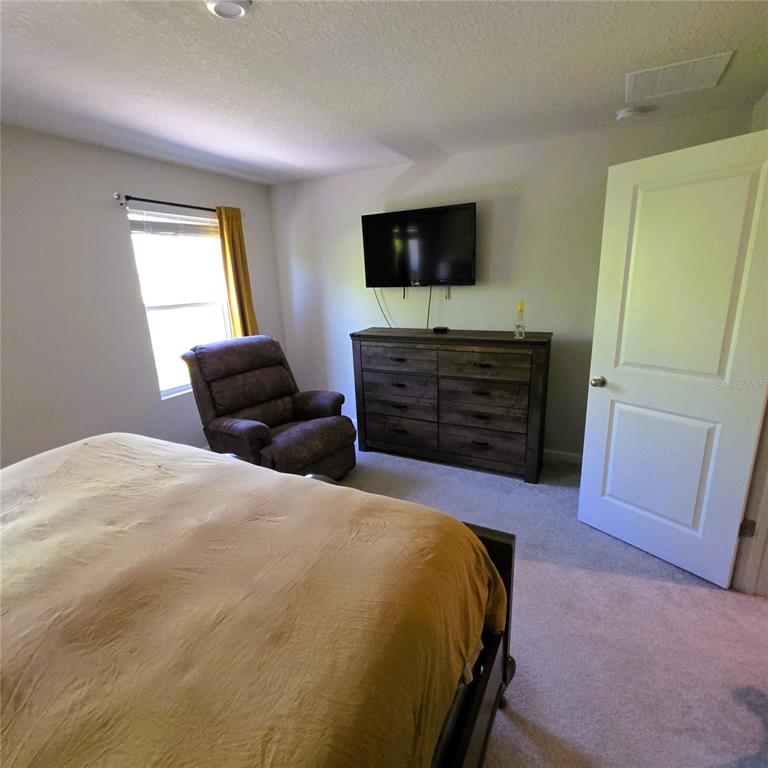 3087 Victoria Inlet Drive Holiday, FL 34691 - Photo 28 of 46 a bedroom with a bed and a flat screen tv