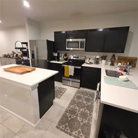 a kitchen with a sink and a stove top oven with wooden floor