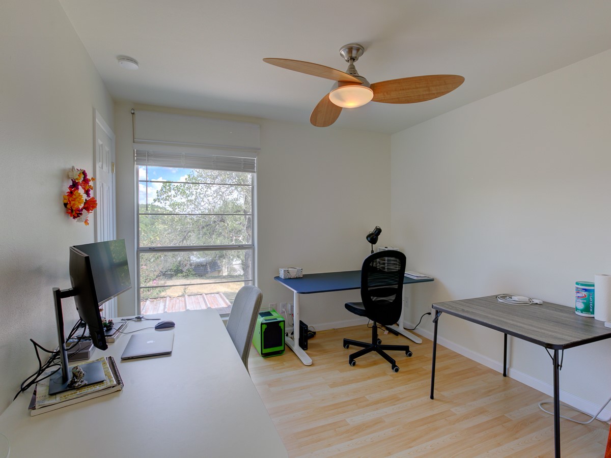 710 Castle Ridge Road, Unit B Austin, TX 78746 - Photo 21 of 27 A versatile home office with light wood flooring and a refreshing ceiling fan.