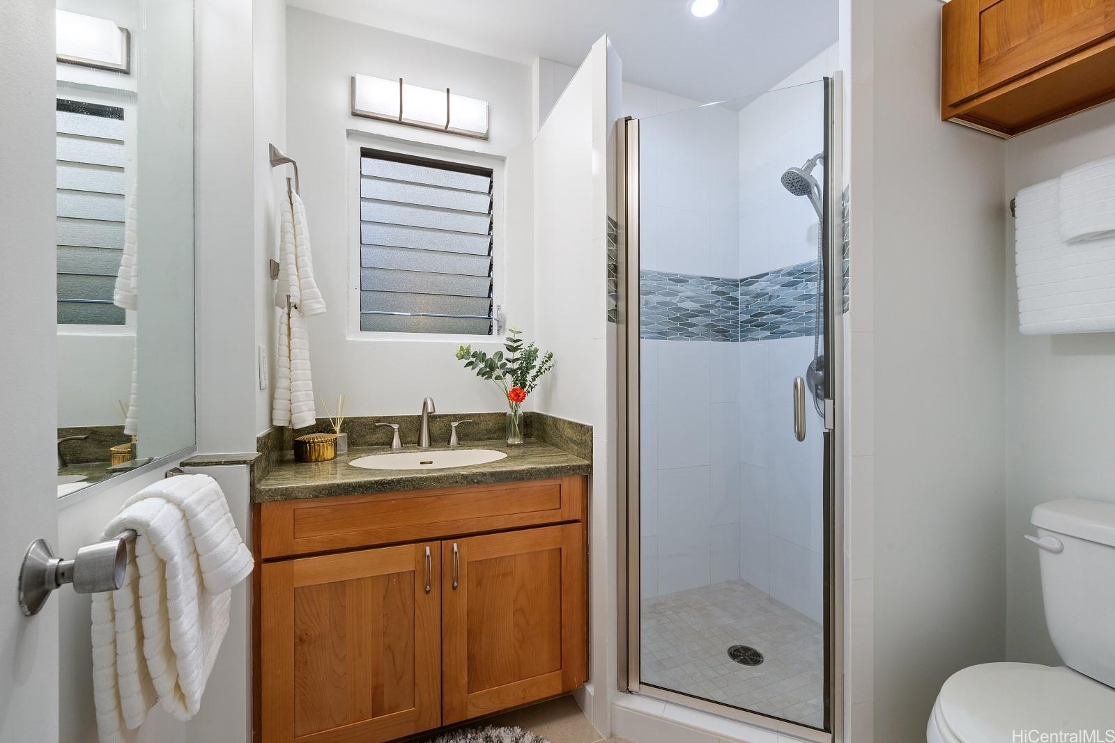 2957 Kalakaua Avenue, Unit 102 Honolulu, HI 96815 - Photo 12 of 15 a bathroom with a granite countertop sink toilet and shower