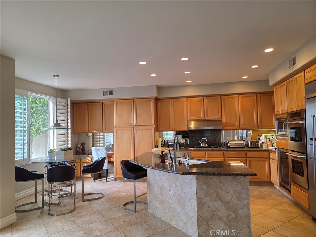 17 Avignon Newport Coast, CA 92657 - Photo 12 of 19 a kitchen with granite countertop a refrigerator and chairs