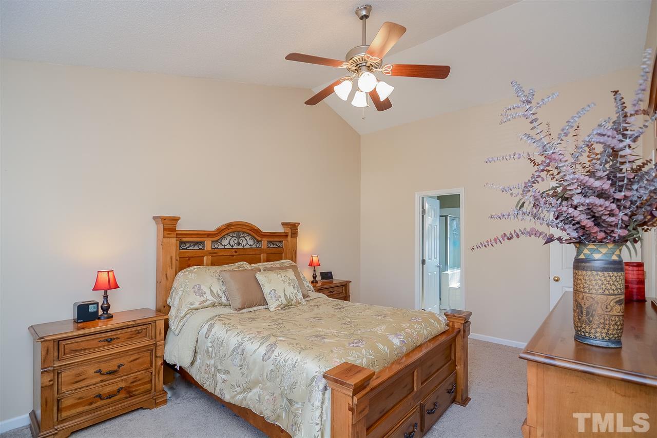 4404 Labrador Drive Raleigh, NC 27616 - Photo 11 of 25 a bedroom with a bed and a chandelier