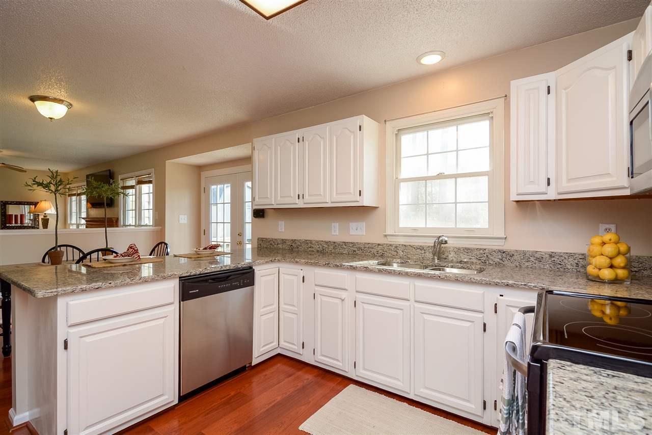 4404 Labrador Drive Raleigh, NC 27616 - Photo 3 of 25 a kitchen with granite countertop white cabinets and white appliances