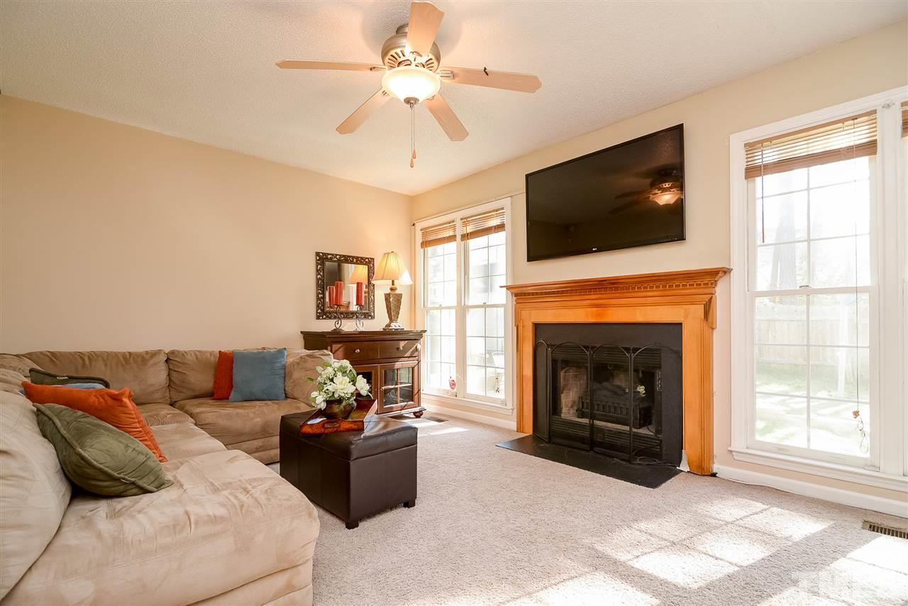 4404 Labrador Drive Raleigh, NC 27616 - Photo 9 of 25 a living room with furniture a flat screen tv and a fireplace