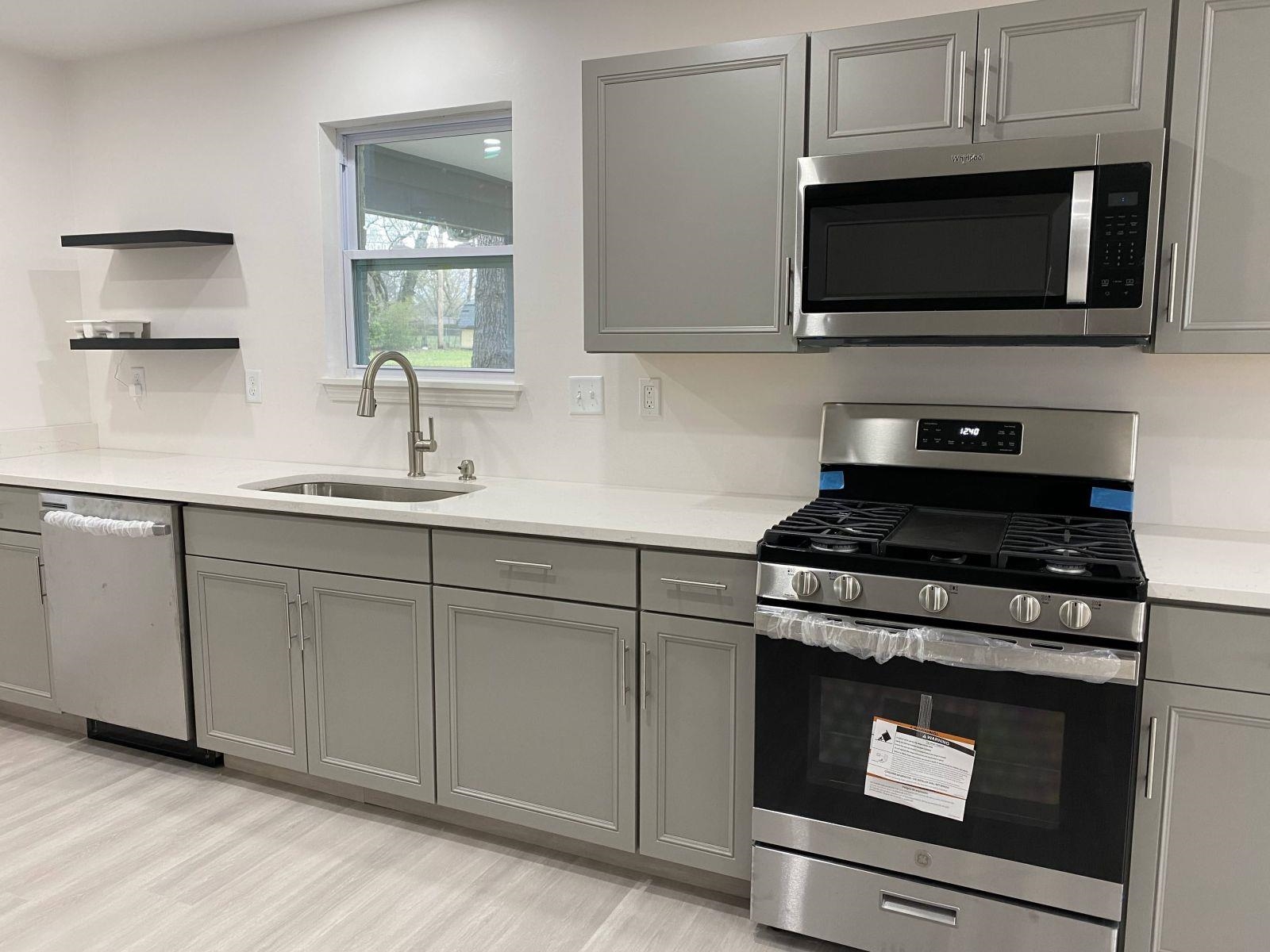 5089 Horn Lake Road Memphis, TN 38109 - Photo 5 of 23 a kitchen with cabinets stainless steel appliances and wooden floor