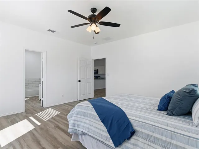 a bedroom with a large bed and a ceiling fan