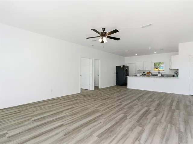 a view of a kitchen with a ceiling fan and hardwood floor