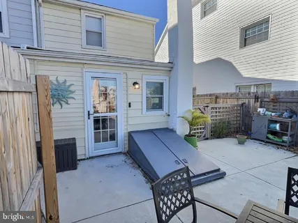 a backyard of a house with barbeque oven table and chairs