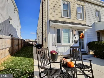 a view of a patio with table and chairs potted plants and floor to ceiling window and wooden floor