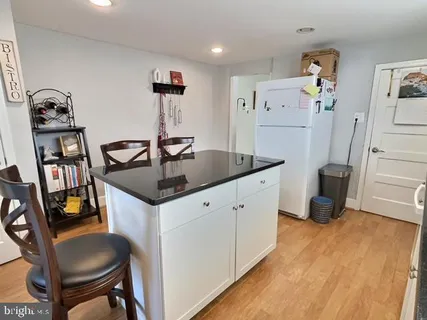 a kitchen with stainless steel appliances kitchen island a refrigerator sink and wooden floor