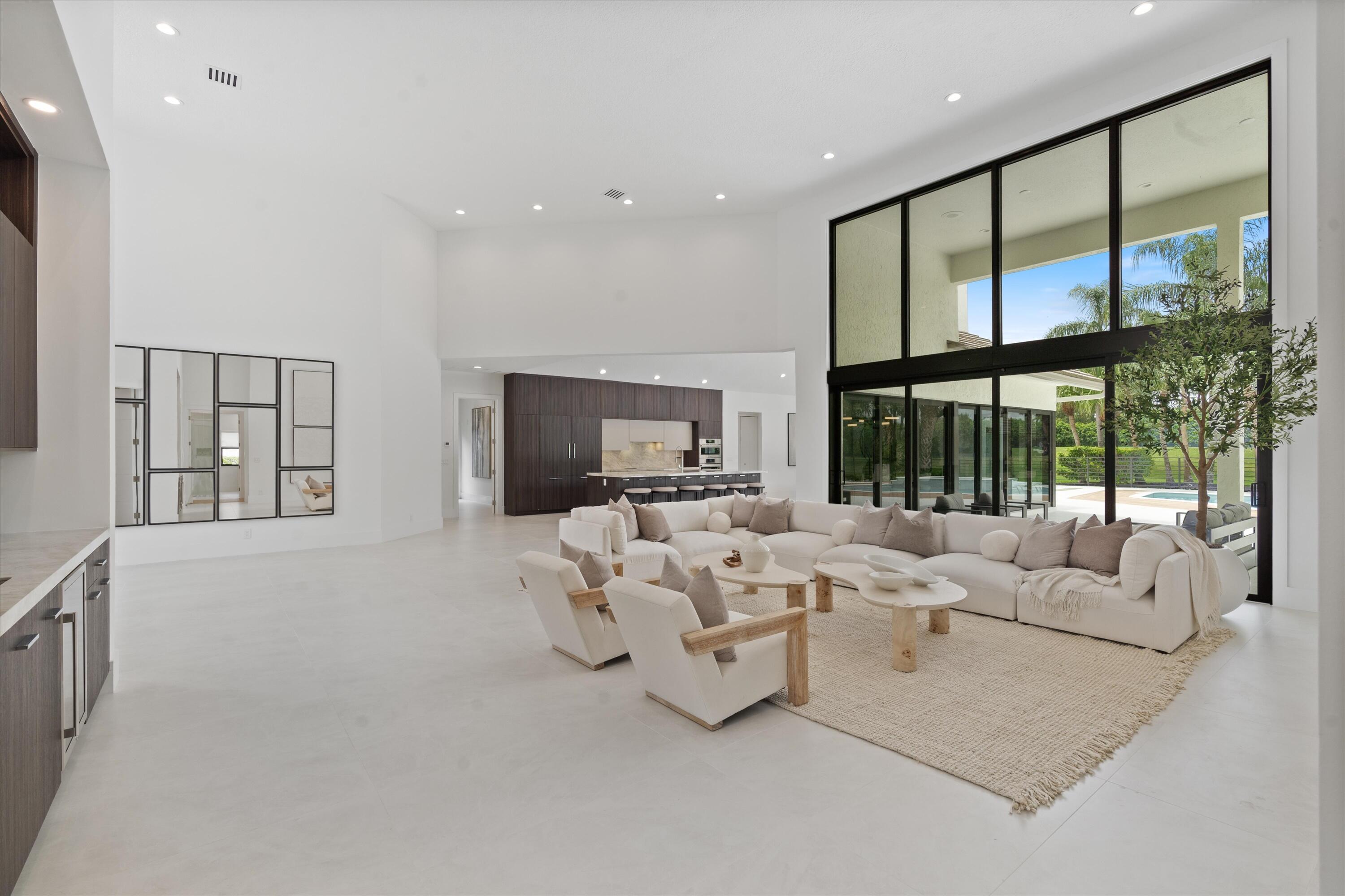 4816 Bocaire Boulevard Boca Raton, FL 33487 - Photo 11 of 61 a living room with furniture large windows and a flat screen tv