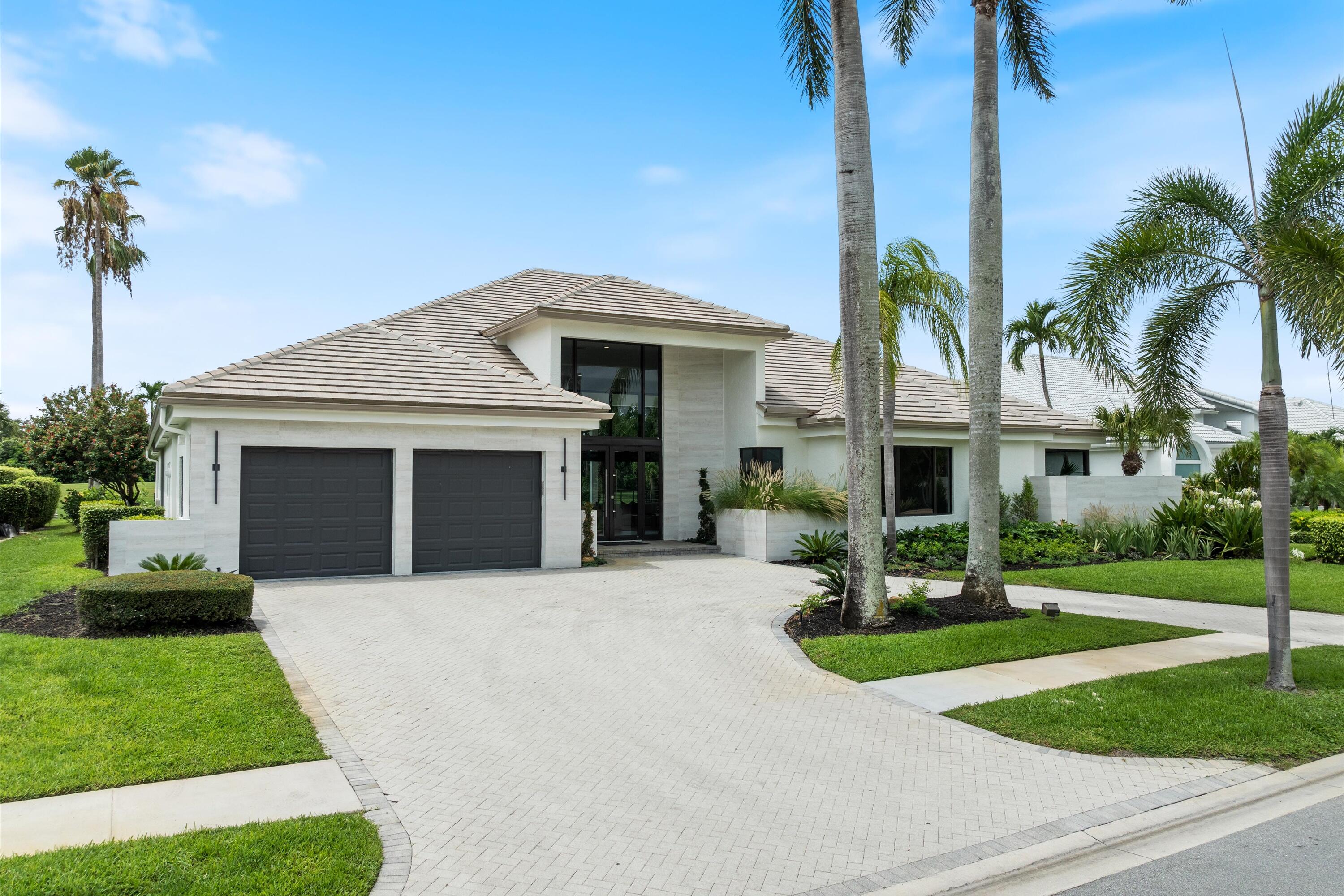 4816 Bocaire Boulevard Boca Raton, FL 33487 - Photo 4 of 61 a front view of a house with a yard and garage