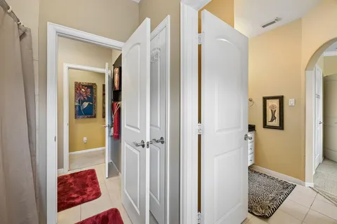 a bedroom with a bed a chandelier and dresser