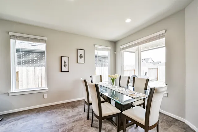 a view of a dining room with furniture large windows and wooden floor
