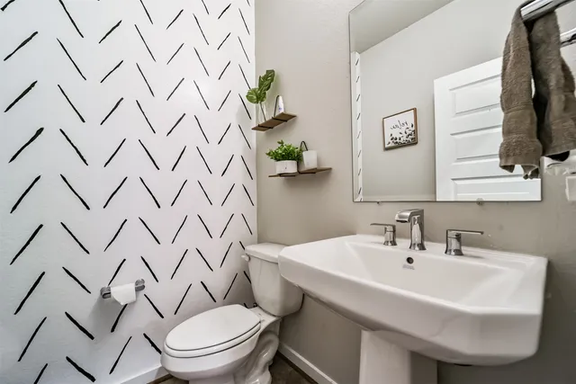 a white sink sitting next to a white toilet and a shower curtain