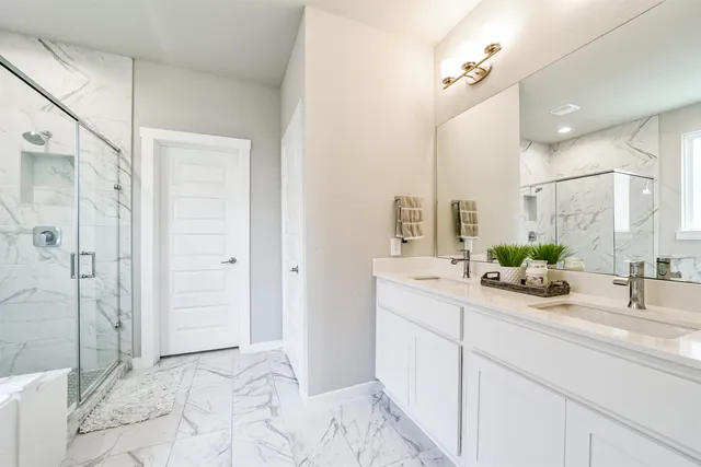 a bathroom with a double vanity sink mirror and shower