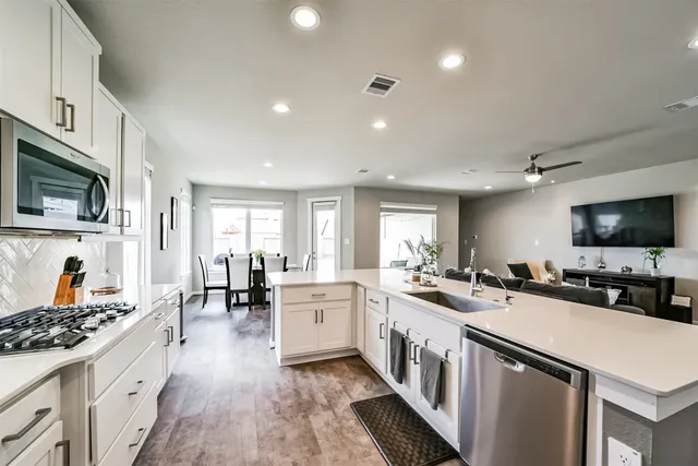 a kitchen with lots of counter top space a sink appliances and cabinets