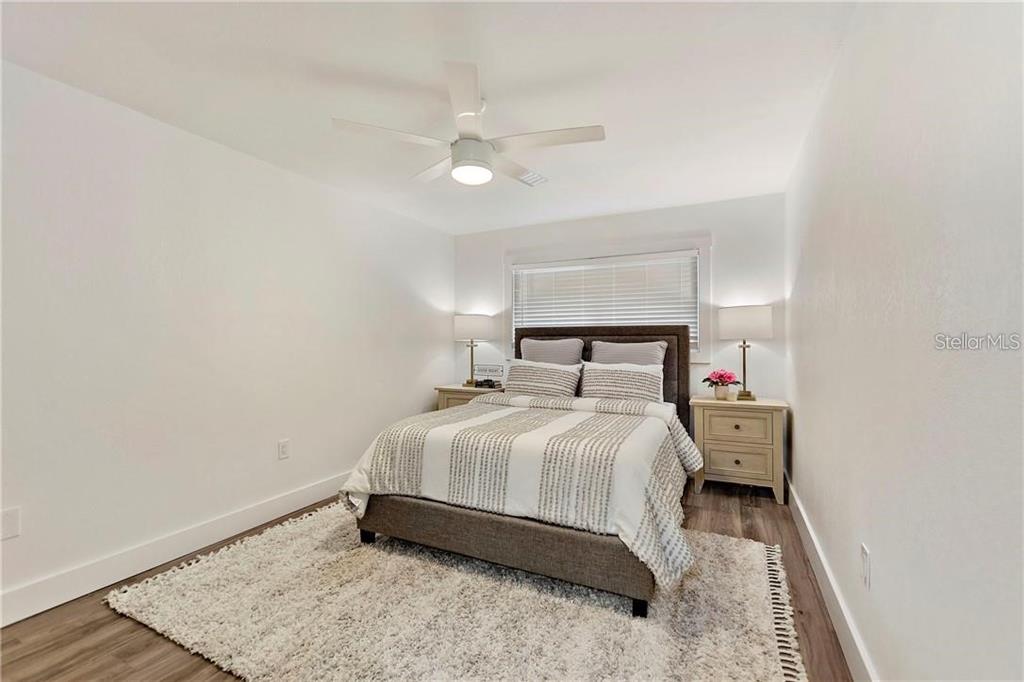 7003 Sunset Way, Unit 4 St. Pete Beach, FL 33706 - Photo 12 of 21 a bedroom with a bed and a night stand
