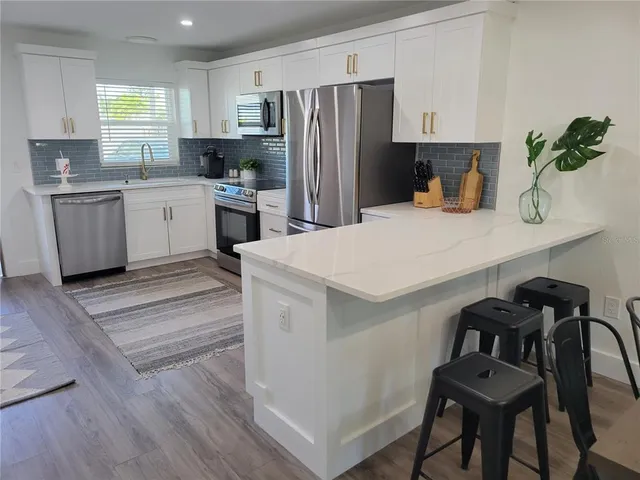 a kitchen with a sink a refrigerator and cabinets