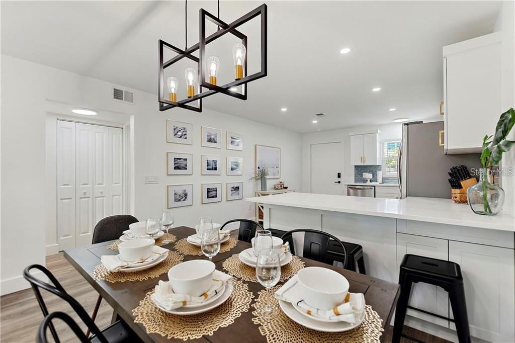 7003 Sunset Way, Unit 4 St. Pete Beach, FL 33706 - Photo 7 of 21 a kitchen with stainless steel appliances kitchen island a table and chairs