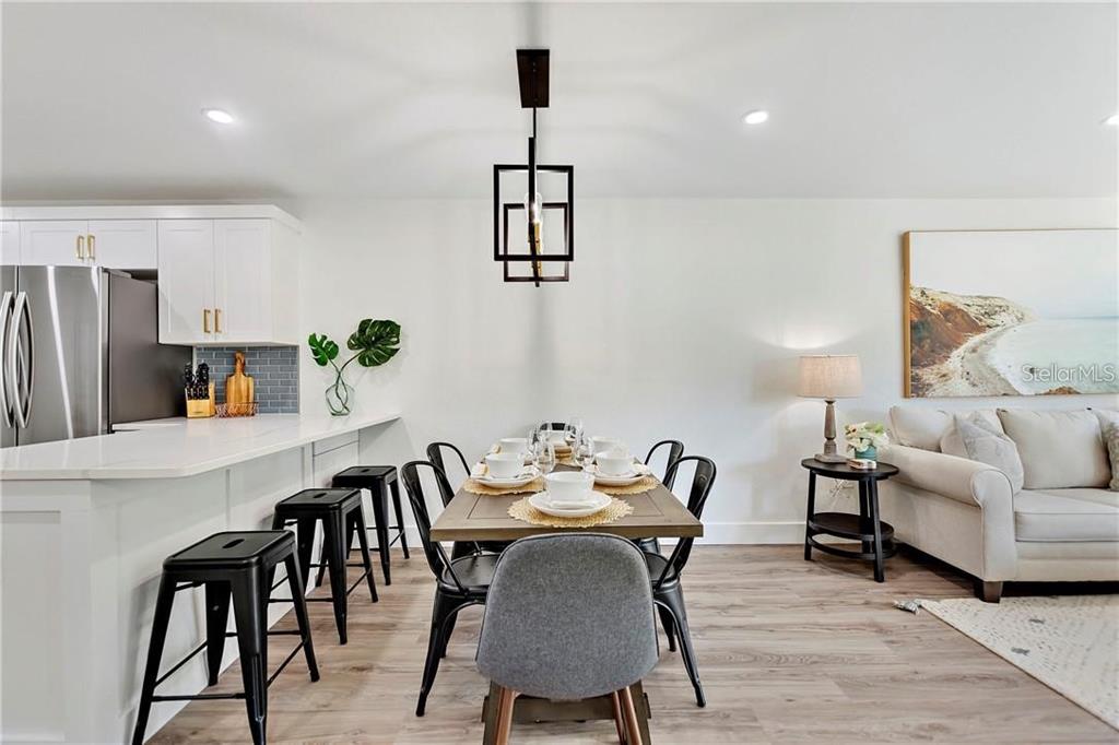 7003 Sunset Way, Unit 4 St. Pete Beach, FL 33706 - Photo 8 of 21 a view of a dining room with furniture and wooden floor