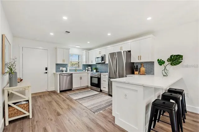 a kitchen with white cabinets and stainless steel appliances