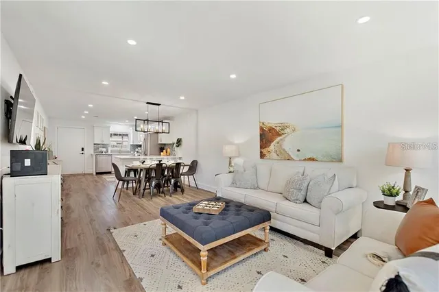 a living room with furniture and a dining table with kitchen view