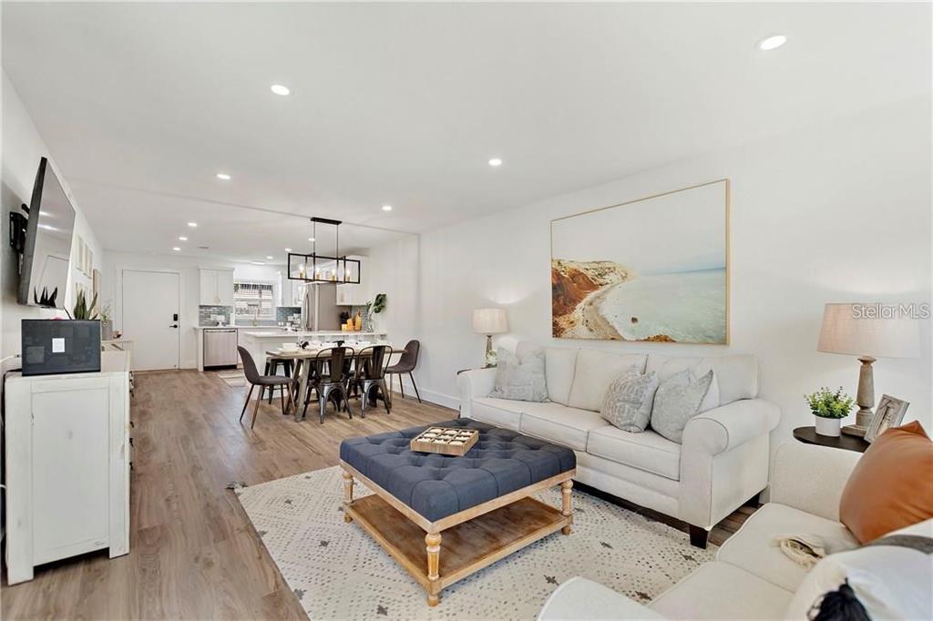7003 Sunset Way, Unit 4 St. Pete Beach, FL 33706 - Photo 10 of 21 a living room with furniture and a dining table with kitchen view