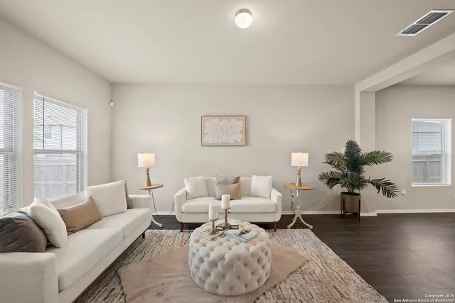a living room with furniture wooden floor and a lamp