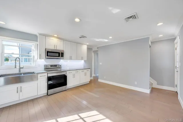 a large kitchen with stainless steel appliances granite countertop a stove and a sink