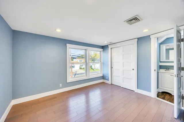 a view of empty room with wooden floor and window