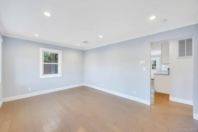 a view of a big room with windows and chandelier fan