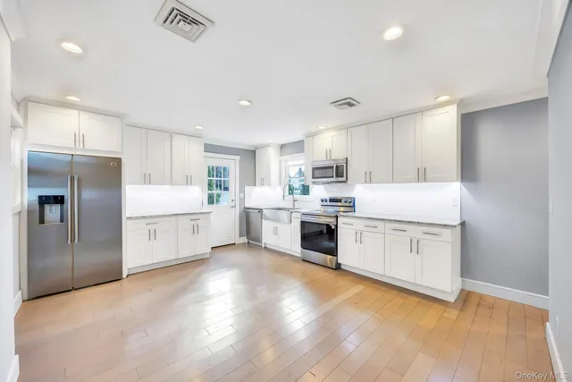 a kitchen with white cabinets and stainless steel appliances