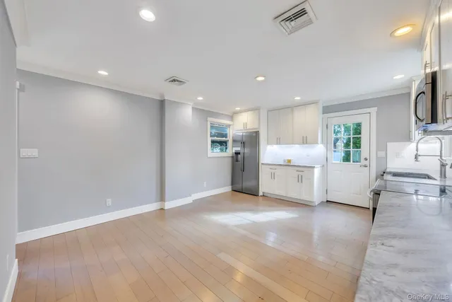 a view of a kitchen with a sink a refrigerator and a window