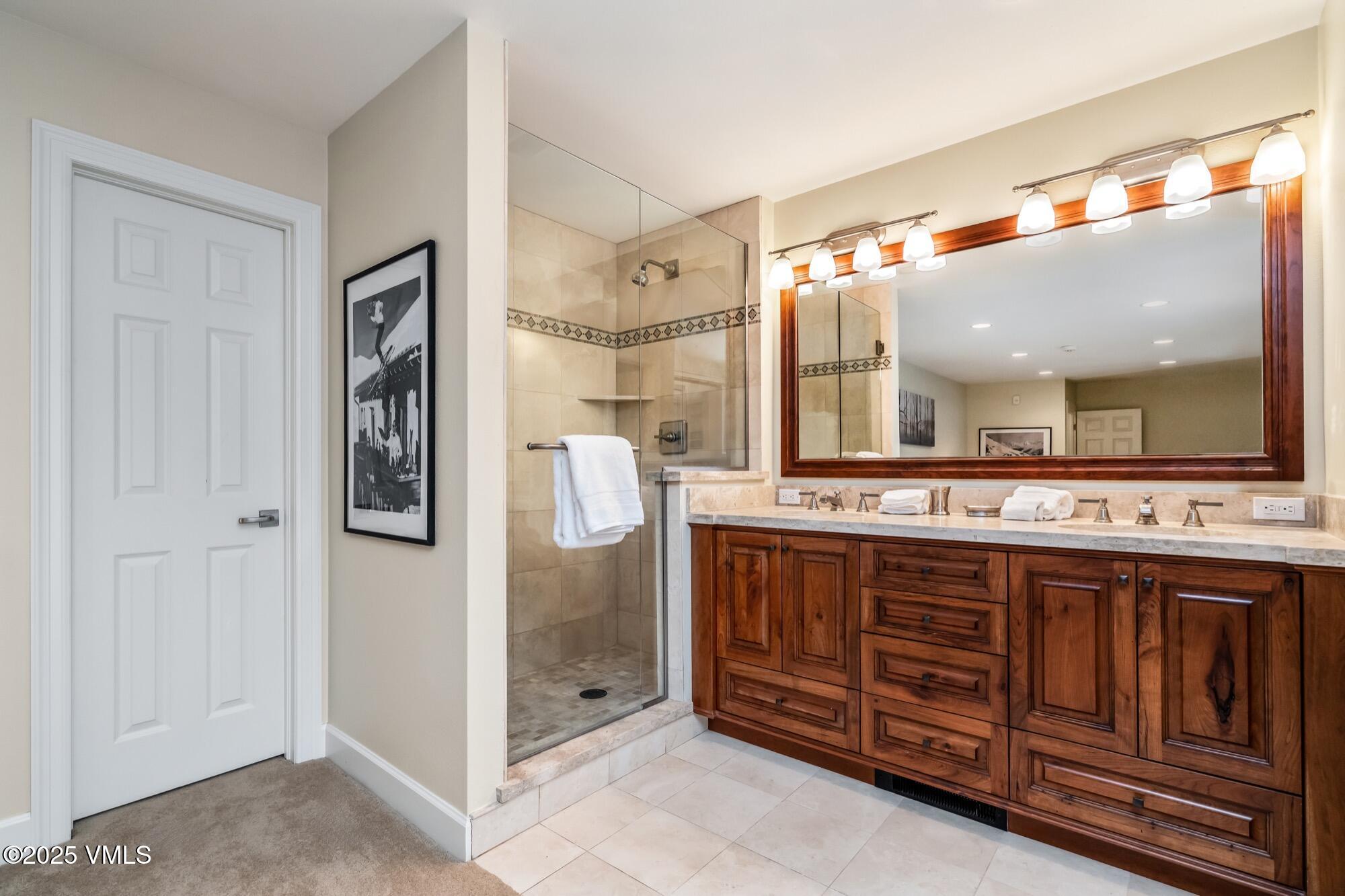 945 Red Sandstone Road, Unit A5 Vail, CO 81657 - Photo 23 of 38 a bathroom with a granite countertop sink mirror and shower