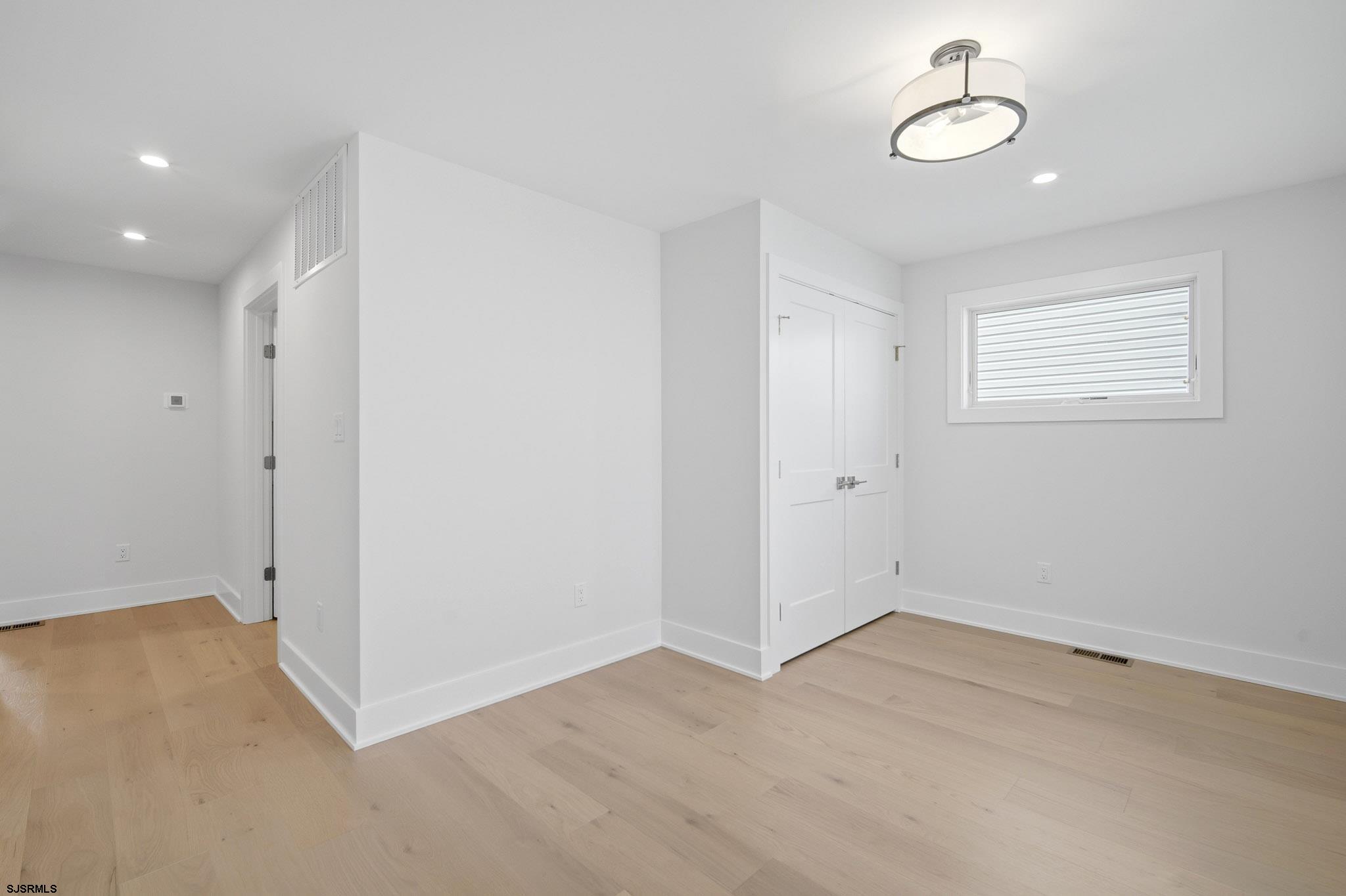 230 7th Street South Brigantine, NJ 08203 - Photo 13 of 87 an empty room with a chandelier fan and windows