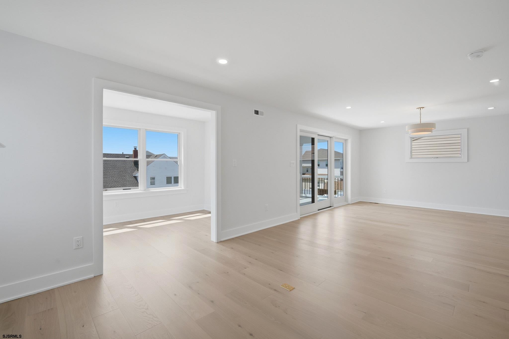 230 7th Street South Brigantine, NJ 08203 - Photo 28 of 87 a view of an empty room with wooden floor and a window