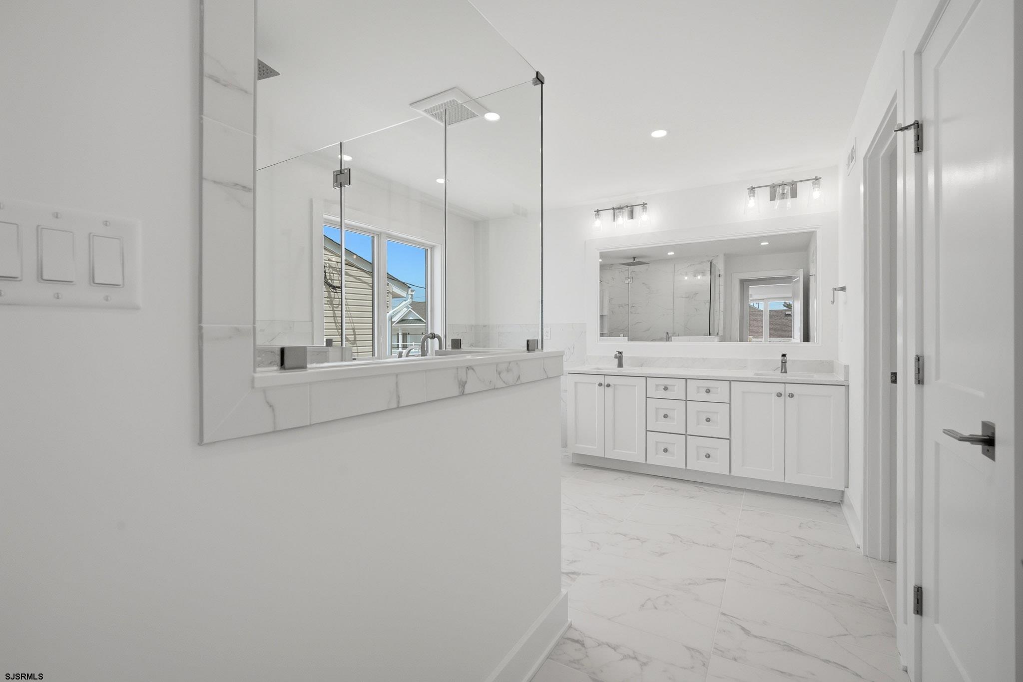 230 7th Street South Brigantine, NJ 08203 - Photo 41 of 87 a bathroom with a double vanity sink a mirror a shower and a bathtub