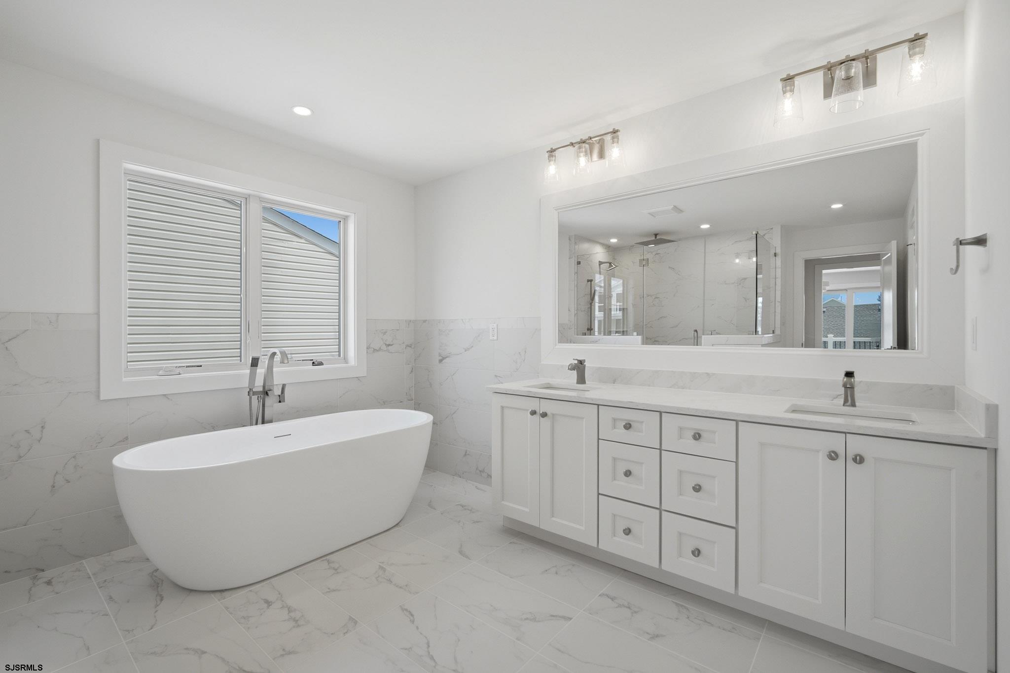 230 7th Street South Brigantine, NJ 08203 - Photo 42 of 87 a spacious bathroom with a double vanity sink mirror and a bathtub