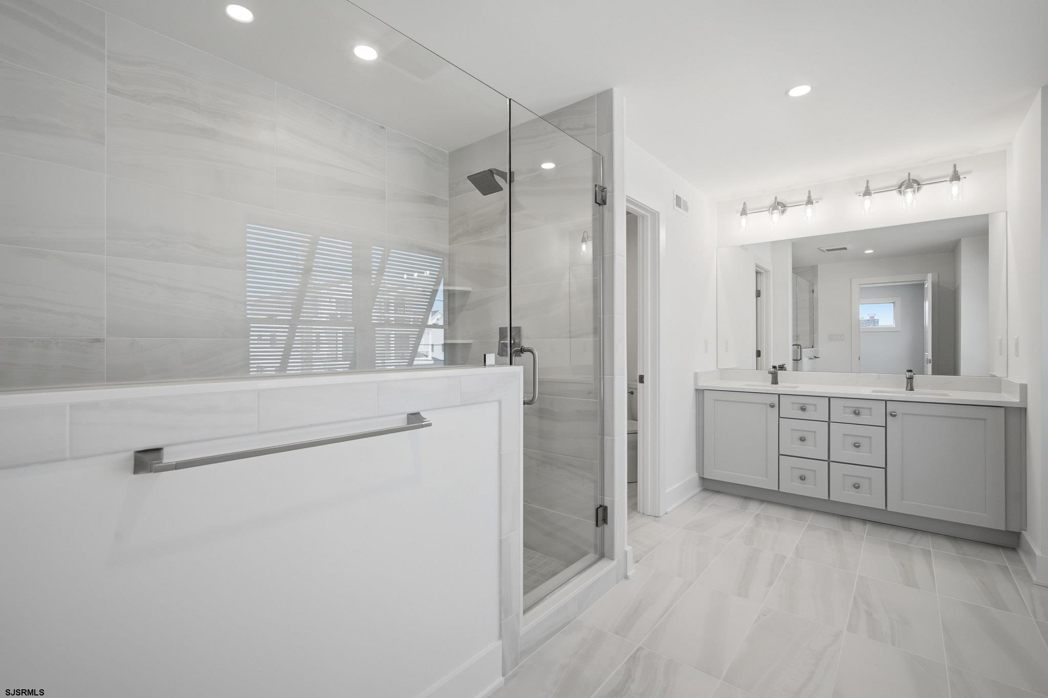 230 7th Street South Brigantine, NJ 08203 - Photo 48 of 87 a spacious bathroom with a shower a sink and a mirror