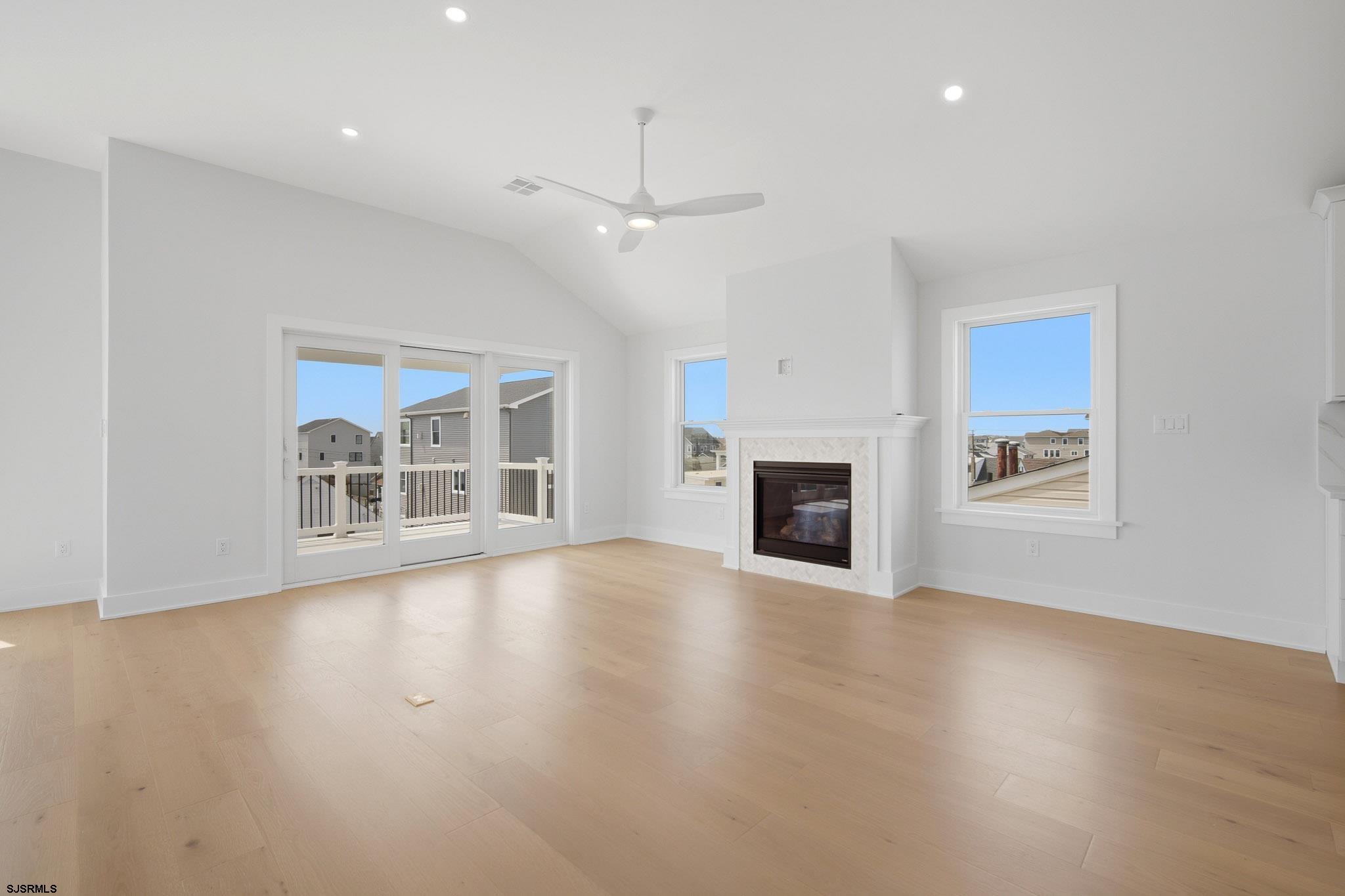 230 7th Street South Brigantine, NJ 08203 - Photo 54 of 87 an empty room with wooden floor fireplace and windows