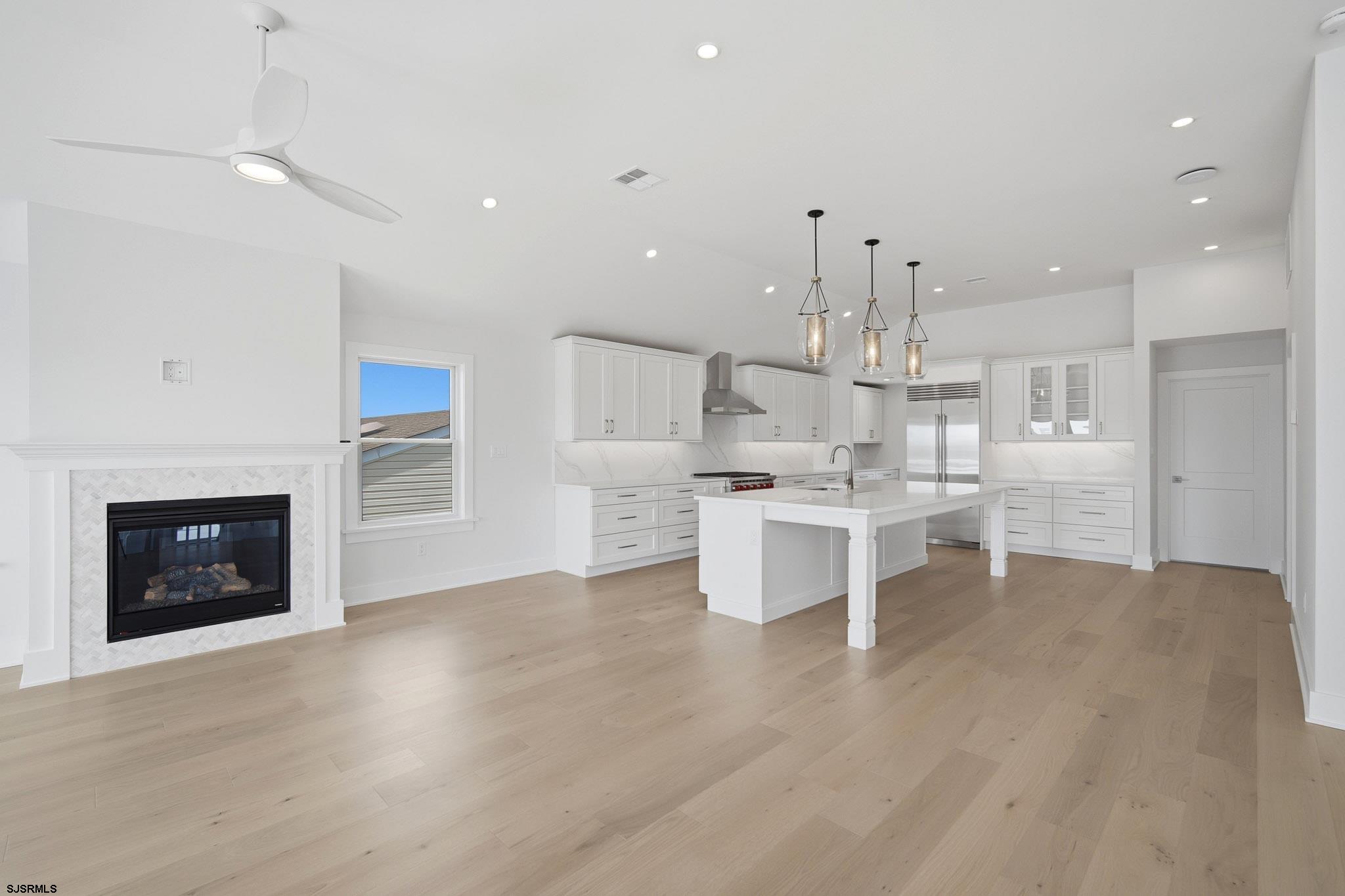 230 7th Street South Brigantine, NJ 08203 - Photo 68 of 87 a large white kitchen with kitchen island a stove a oven a sink dishwasher and a fireplace with wooden floor