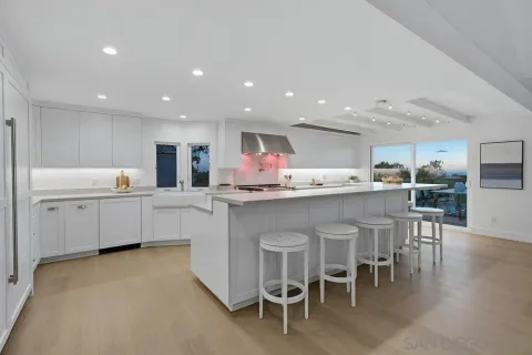 a kitchen with a sink and chairs